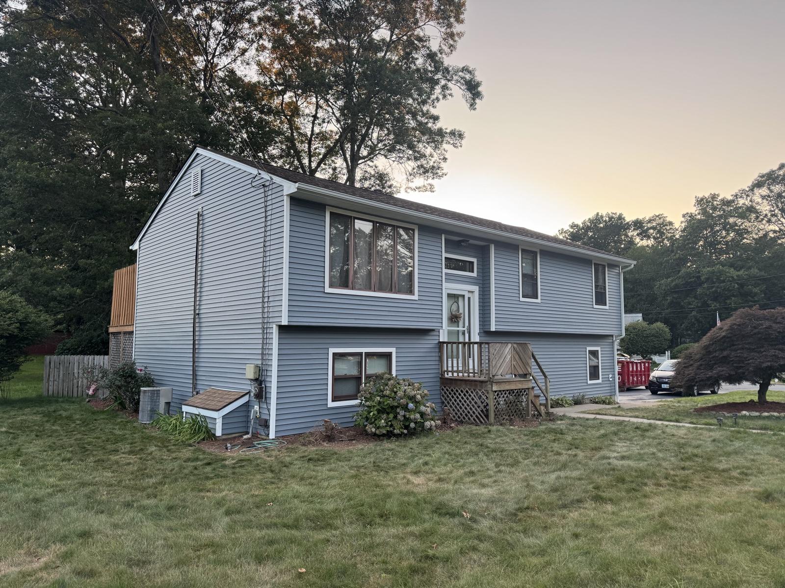 After: Home siding replacement — worn wood siding replaced with new blue-gray lap siding