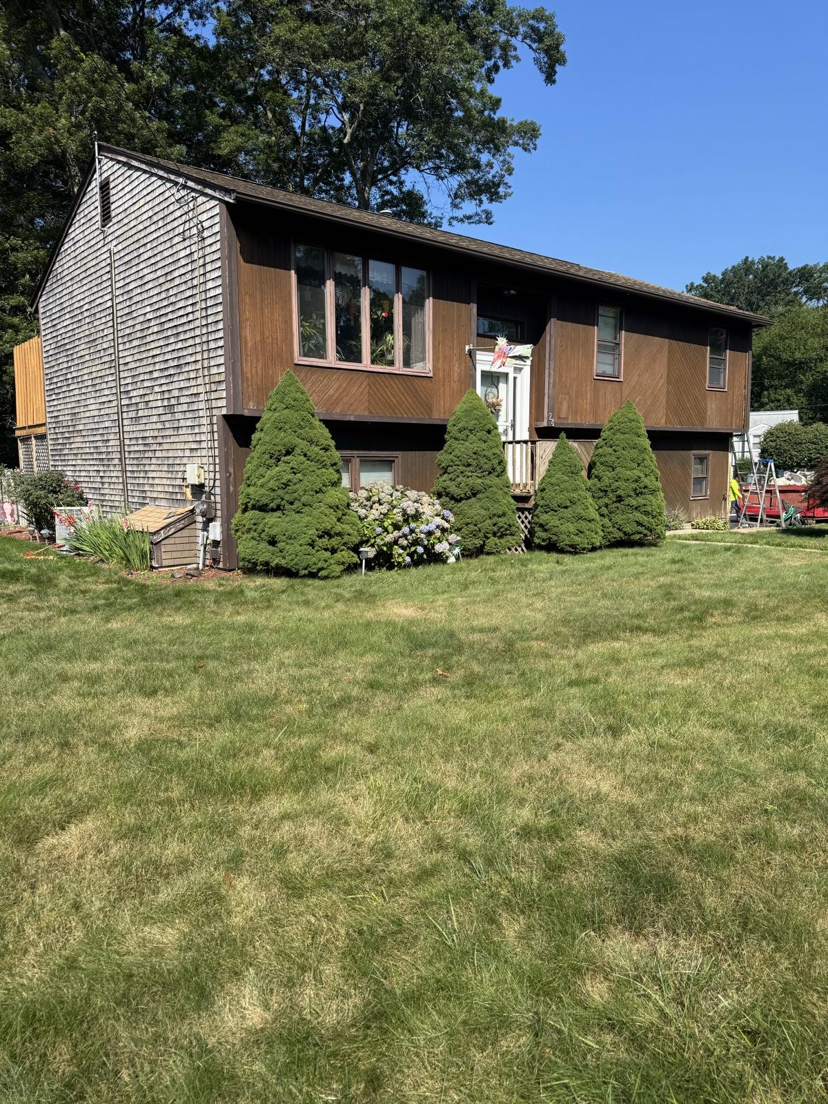 Before: Home siding replacement — worn wood siding replaced with new blue-gray lap siding